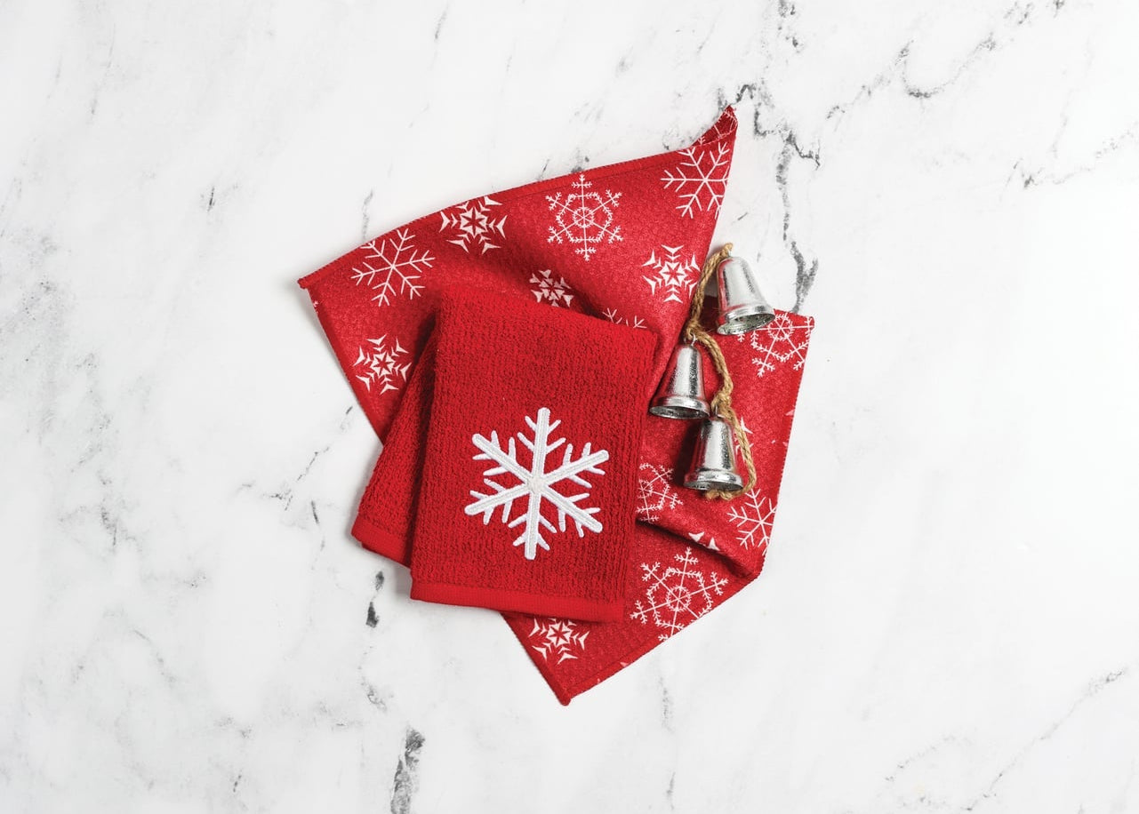Red Christmas-themed napkins with snowflakes and bells on a marble surface